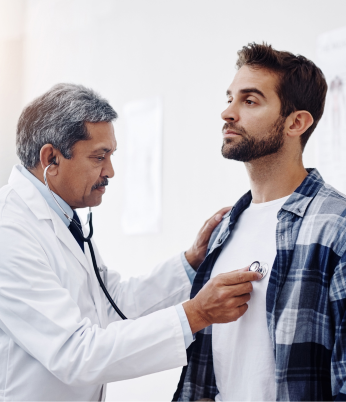Paciente mulher sorrindo sendo acolhida por profissional de medicina. Programa de apoio ao paciente crônico gerencia a saúde de pacientes com determinadas doenças crônicas e os auxilia nos tratamentos em geral e em eventuais complicações. Fornece orientações, esclarecimentos e suporte emocional por telefone.
