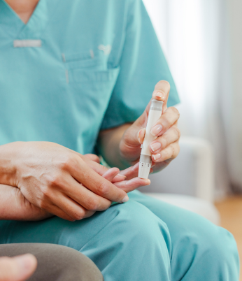 Paciente mulher sorrindo sendo acolhida por profissional de medicina. Programa de apoio ao paciente crônico gerencia a saúde de pacientes com determinadas doenças crônicas e os auxilia nos tratamentos em geral e em eventuais complicações. Fornece orientações, esclarecimentos e suporte emocional por telefone.