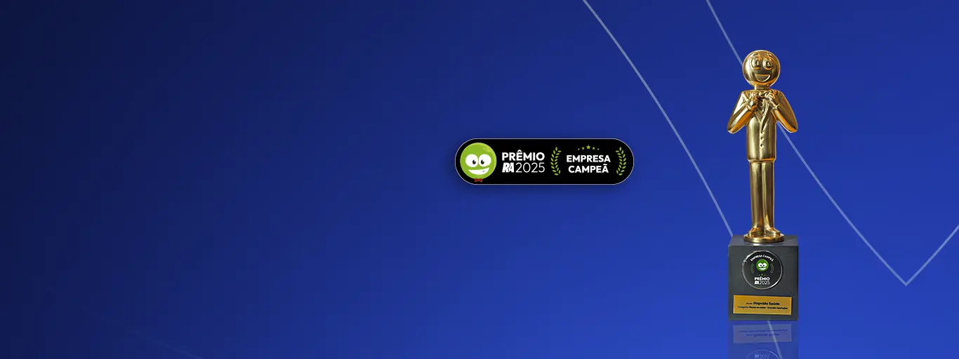 Homem sentado no sofá olhando para o celular e sorrindo.