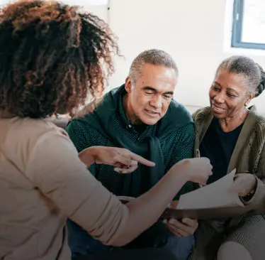 Mulher explicando algo para um casal de senhores