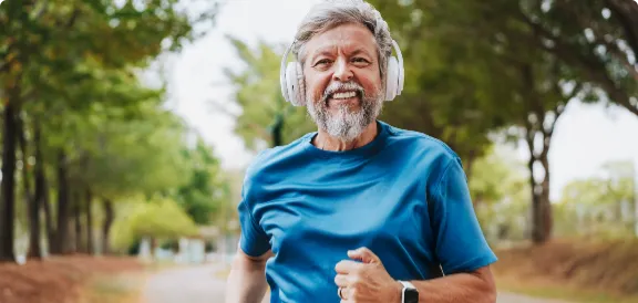 Homem correndo de fone na rua.